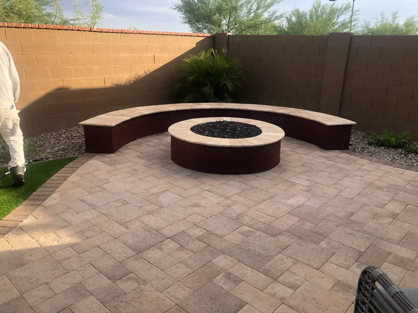 Freshly painted curved outdoor firepit seating area on a finished paver patio