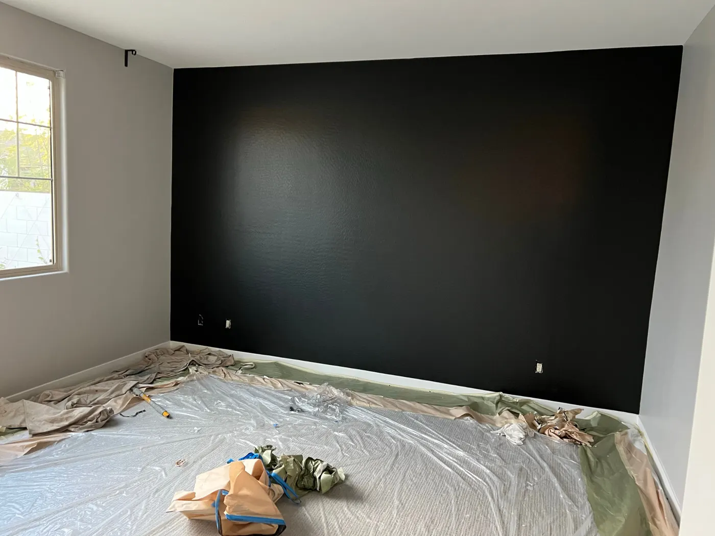 Finished matte black bedroom accent wall with crisp ceiling and corner lines