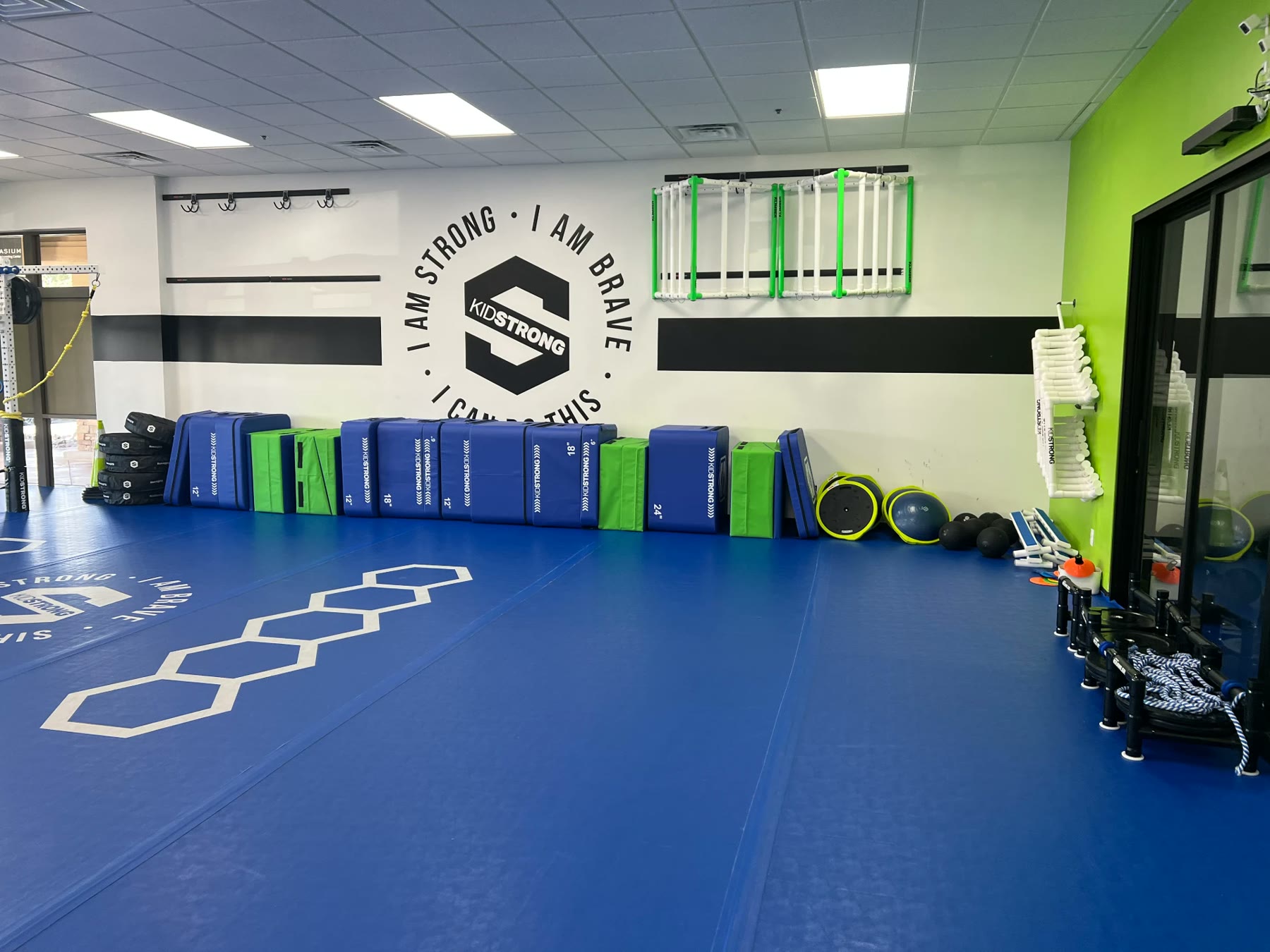 Commercial gym interior painted with white, black, and green walls